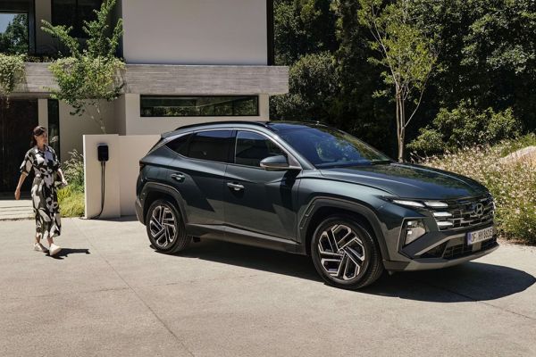 Frau läuft auf einen geparkten Hyundai TUCSON zu